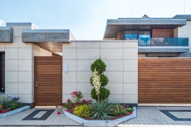 Modern home entry with clean plantings and trimmed topiary